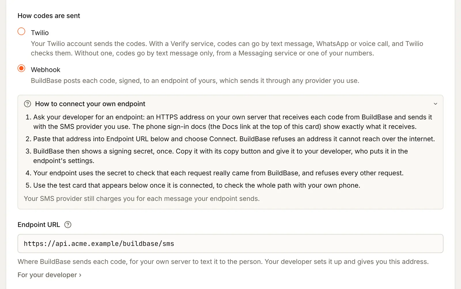 Webhook chosen: the guide How to connect your own endpoint in five steps, and the Endpoint URL box with https://api.acme.example/buildbase/sms typed in